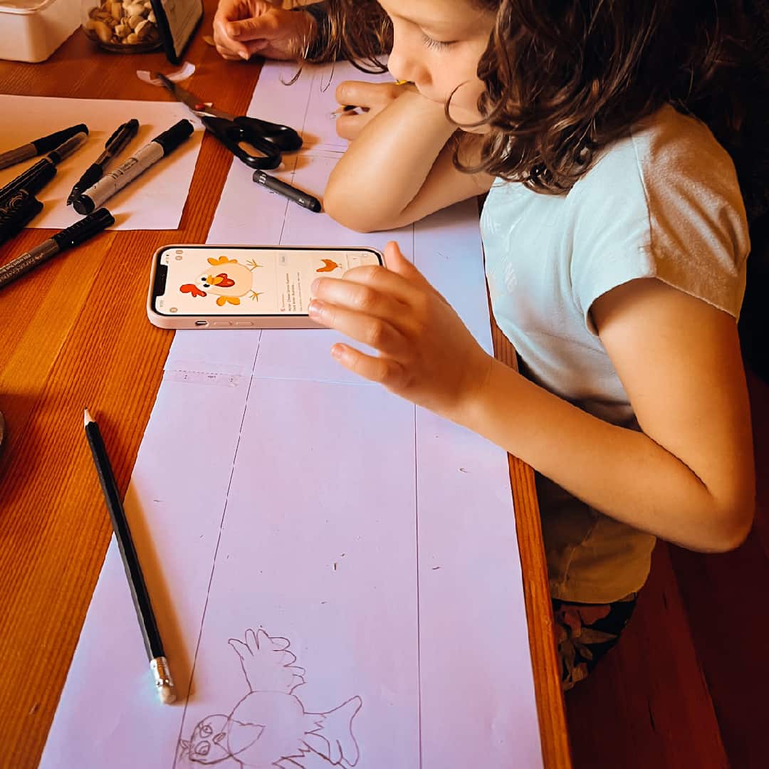 A girl makes a drawing that we will knit into a soft children's scarf.