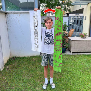 We maken van kindertekeningen zacht gebreide kindersjaals. Hier laat een jongen zijn tekening van een raket zien die we in een sjaal hebben gebreid. Als je jouw eigen Relooped sjaal ontwerpt, kun je je eigen kleurencombinatie kiezen en je sjaal personaliseren met je voornaam.