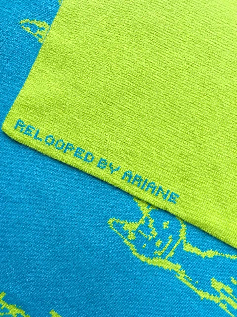 Detail van gebreide sjaal met persoonlijke naam subtiel in de zoom verwerkt