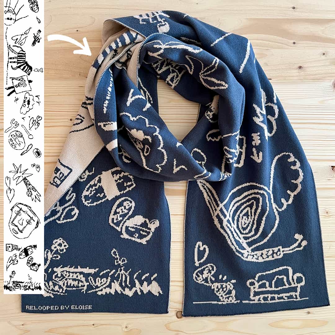 Gebreide sjaal voor volwassenen naast de originele tekening waarop het ontwerp is gebaseerd